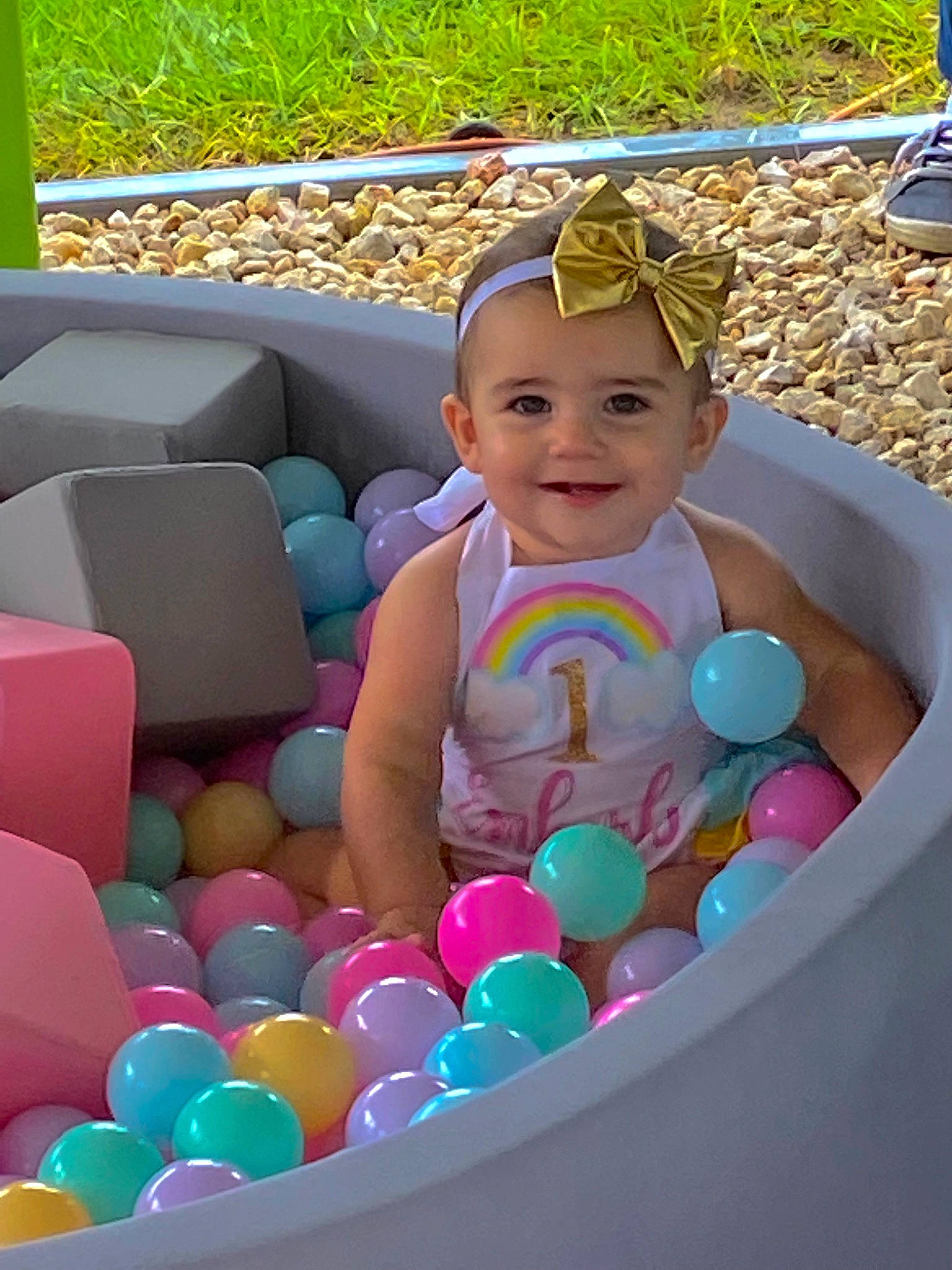 Emberly is registered to the contest to win money with this photo: baby, baby_playing_with_toys, baby_products, baby_toddler_clothing, child, event, facial_expression, fun, grass, happy, head, headwear, joy, leisure, party_supply, person, pink, play, recreation, sitting