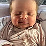 Sadie is registered to the contest to win money with this photo: baby, infant, sleeping, close_up, onesie, floral_pattern, peaceful, hands, soft_lighting, face, skin, cute, child, newborn, indoors, portrait, peaceful_expression, sleep, small, cozy
