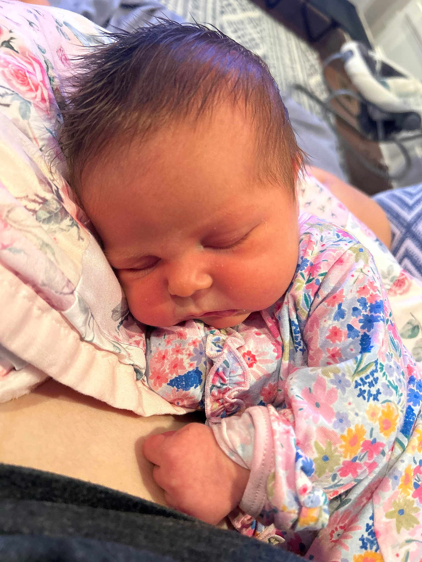 Sadie is registered to the contest to win money with this photo: baby, newborn, sleeping, floral, blanket, onesie, infant, closeup, face, hand, soft_lighting, cute, peaceful, resting, child, person, indoors, cozy, portrait, toddler