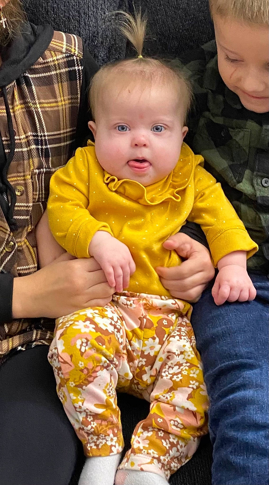 Jaylynn joined the competition — help win amazing prizes! baby, baby_toddler_clothing, cheek, child, event, eye, face, grass, happy, head, human_body, lap, organ, people, person, sitting, skin, sleeve, smile, tartan