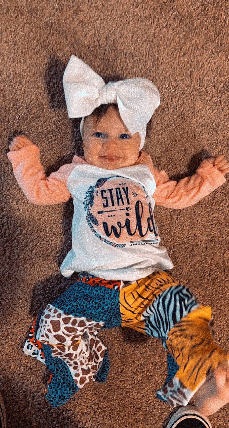 Gracelynn is registered to the contest to win money with this photo: baby_toddler_clothing, brown, cap, child, cool, costume_hat, fun, gesture, happy, headgear, mammal, orange, person, sleeve, smile, t_shirt, textile, toddler, tree, white