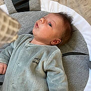 Liam participe au concours pour gagner de l'argent avec cette photo : baby, infant, face, person, clothing, onesie, cushion, soft_fabric, lying_down, indoor, curious, young_child, head, skin, expression, small_hands, sleepwear, comfortable, resting, child