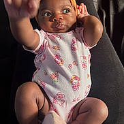 Kaylee is registered to the contest to win money with this photo: baby, infant, child, onesie, headband, orange, pink, hello_kitty, hand, feet, soft_slippers, cute, curious, lying_down, portrait, indoors, skin, person, apparel, expression