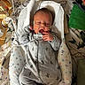 Fisher is registered to the contest to win money with this photo: baby, infant, newborn, medical_equipment, hospital, nasal_cannula, gray_onesie, cactus_pattern, blanket, heart_pattern, lying_down, hand, face, person, cute, sleepy, bed, nursery, healthcare, monitoring