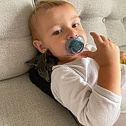 Liam a rejoint le concours — aidez-le/la à gagner de superbes lots ! casual, child, couch, cozy, cute, domestic_animal, fabric, face, furniture, gray_cat, hand, indoor, pacifier, pet, relaxing, resting, sofa, toddler, white_shirt, young_child