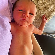 Noah is registered to the contest to win money with this photo: newborn, baby, infant, diaper, blanket, soft_texture, close_up, curious_expression, skin, hand, arm, person, indoors, clothing, purple_cloth, light, nap, resting, human, cute