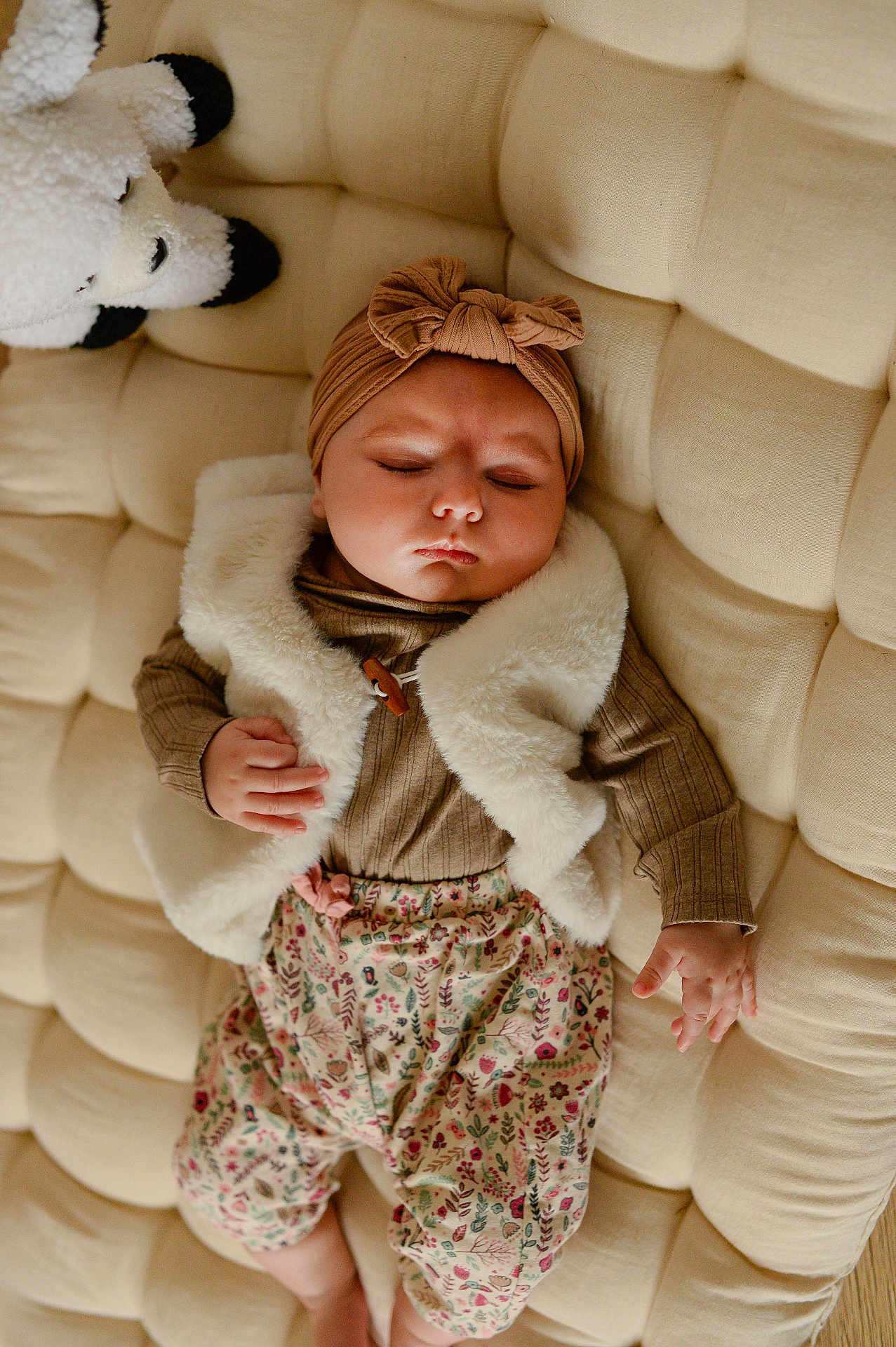 Eva participe au concours pour gagner de l'argent avec cette photo : baby, sleeping, infant, plush, cushion, stuffed_animal, headwear, vest, patterned_clothing, hand, face, indoor, soft_fabric, child, peaceful, cozy, rest, cute, toddler, relaxation