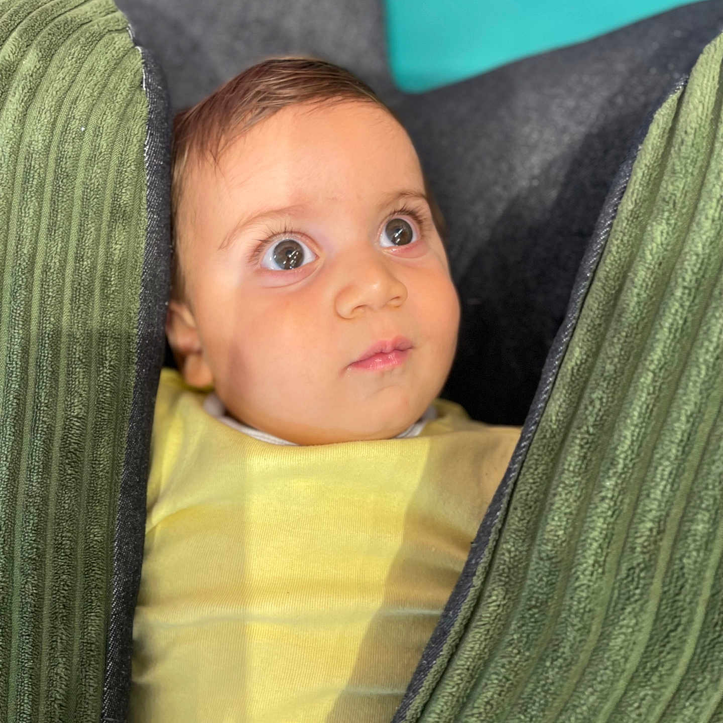 Toma a rejoint le concours — aidez-le/la à gagner de superbes lots ! baby, child, closeup, curious, cushion, expression, eyes, fabric, face, green, head, indoors, infant, portrait, seated, skin, soft_light, texture, yellow_clothing, young_child