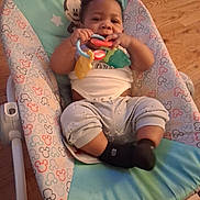 Nakiyis joined the competition — help win amazing prizes! baby, infant, child, smiling, sitting, bouncer, baby_seat, rattle, teething_toy, toy, mickey_mouse, colorful, clothing, shirt, pants, socks, indoor, hardwood_floor, portrait, happy
