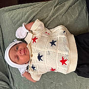 Brayden is registered to the contest to win money with this photo: baby, infant, knit_sweater, stars, white_hat, mittens, green_blanket, lying_down, cute, peaceful, clothing, portrait, newborn, young_child, indoor, soft_texture, comfort, relaxation, child, person