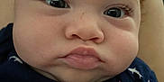 Lejend is registered to the contest to win money with this photo: baby, face, close_up, child, curly_hair, red_hair, blue_clothing, shark_pattern, cute, expression, eyes, lips, skin, infant, person, portrait, young_child, indoors, head, chubby_cheeks