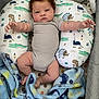 Lejend is registered to the contest to win money with this photo: baby, infant, curly_hair, blanket, pillow, dinosaur_pattern, lying_down, arms_outstretched, soft_texture, cute, child, indoors, cozy, sleeping_area, onesie, baby_bed, playful, resting, comfort, adorable