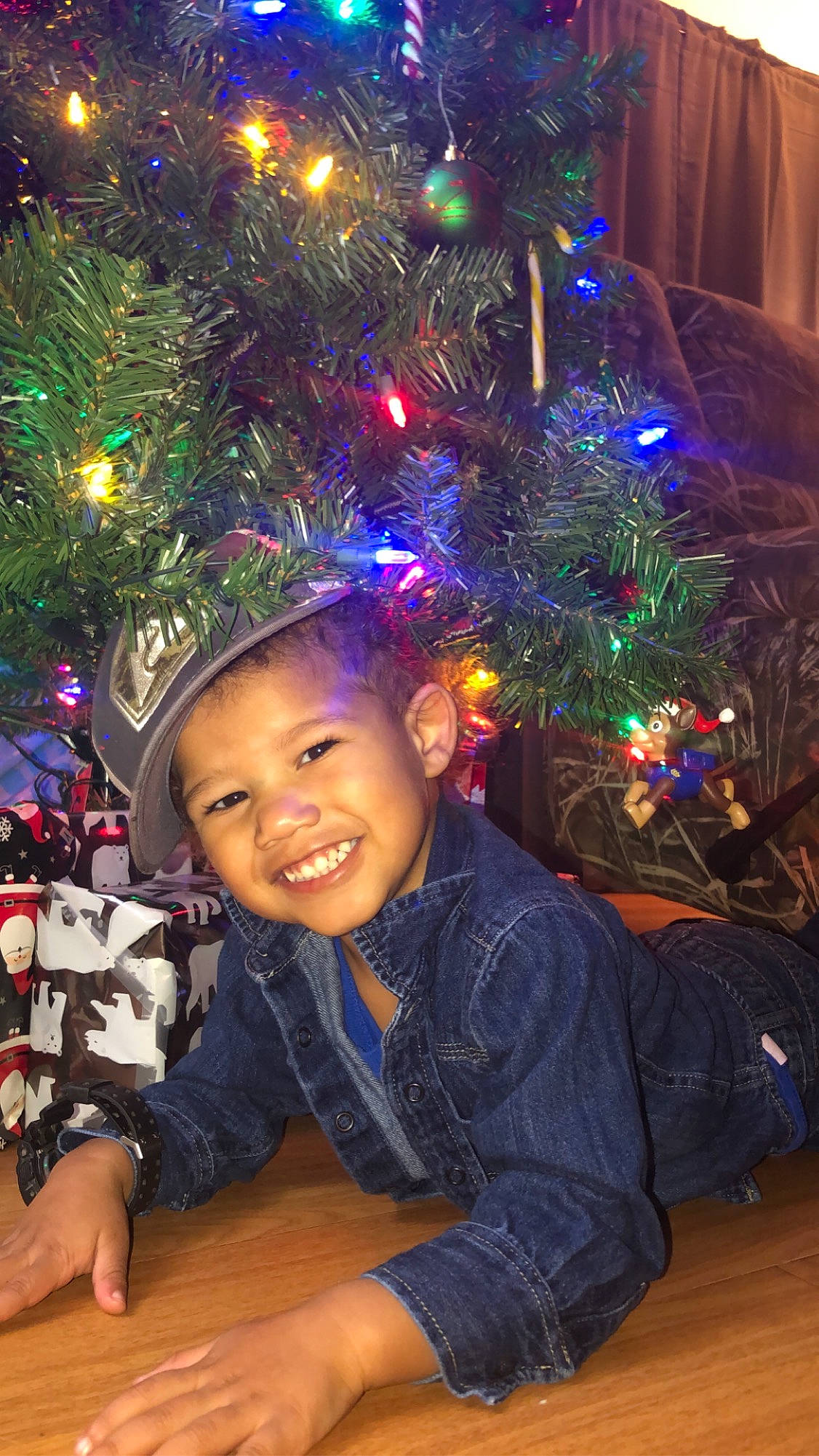 Tre is registered to the contest to win money with this photo: child, christmas, christmas_decoration, christmas_eve, christmas_lights, christmas_ornament, christmas_tree, conifer, event, fir, fun, holiday, holiday_ornament, interior_design, joy, ornament, person, pine_family, plant, smile