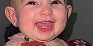 Nour participe au concours pour gagner de l'argent avec cette photo : apple_pattern, baby, cheeks, closeup, drool, ears, eyes, flash, happy, indoor, infant, onesie, pajamas, plain_background, portrait, sitting, skin, smile, toothy_grin, young_child