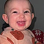 apple_pattern, baby, cheeks, closeup, drool, ears, eyes, flash, happy, indoor, infant, onesie, pajamas, plain_background, portrait, sitting, skin, smile, toothy_grin, young_child