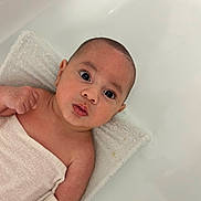 Oshay is registered to the contest to win money with this photo: baby, infant, towel, skin, face, eyes, expression, arm, hand, white, soft, blanket, newborn, cute, portrait, lying_down, child, indoors, head, young