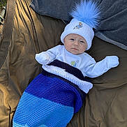 Acer is registered to the contest to win money with this photo: baby, child, hat, pom_pom, blue, blanket, crocheted, clothing, outdoor, mat, denim, face, person, infant, warm, cute, lying_down, winter_wear, expression, cozy