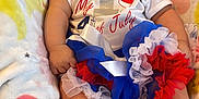 Annalee is registered to the contest to win money with this photo: baby, infant, smiling, headband, flower, blanket, colorful, clothing, red_white_blue, festive, holiday, celebration, sitting, cute, shoes, sock, tutu, portrait, happy, independence_day