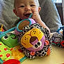 Candor is registered to the contest to win money with this photo: baby, child, smiling, plush_toy, high_chair, indoor, window, blanket, colorful, toy, cheerful, person, face, happy, infant, furniture, soft_toy, playtime, cute, young_child