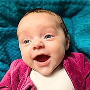 Margaux participe au concours pour gagner de l'argent avec cette photo : baby, infant, smiling, face, blue_eyes, open_mouth, clothing, jacket, pink, purple, teal, knitted_blanket, background, portrait, cute, happy, skin, human, closeup, indoor