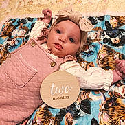 Adalynn joined the competition — help win amazing prizes! baby, infant, child, portrait, lying_down, smiling, wide_eyed, headband, bow, pink_outfit, overalls, blanket, animal_print, tiger_pattern, bed, milestone, two_months, wooden_sign, indoors, cute