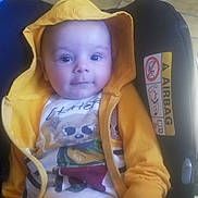 Timothée a rejoint le concours — aidez-le/la à gagner de superbes lots ! baby, car_seat, casual_clothing, child, comfort, cute, face, footwear, hand, hoodie, indoors, infant, person, portrait, seat, sitting, smile, tiled_floor, yellow_clothing, young_child