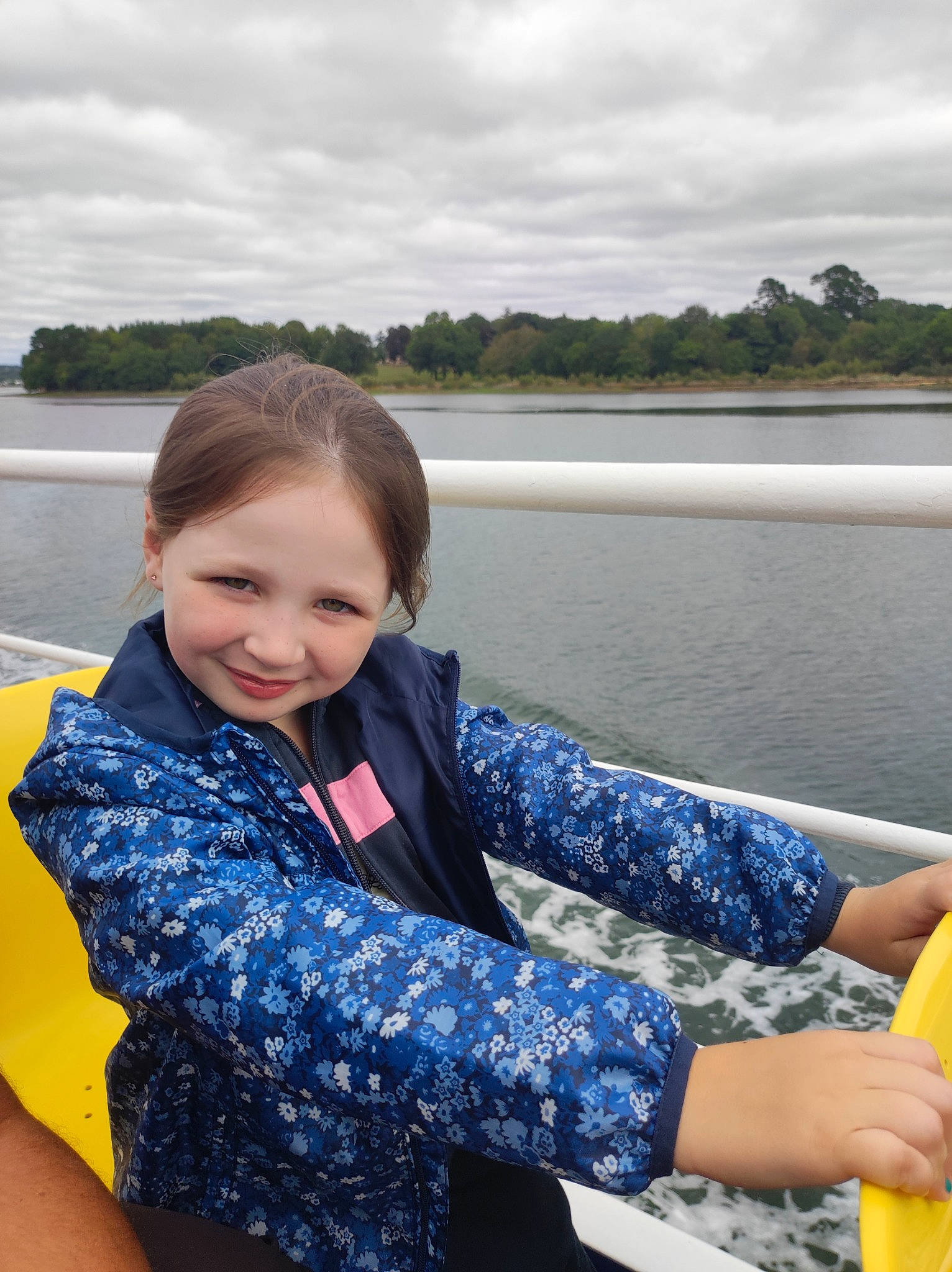 Maïwen participe au concours pour gagner de l'argent avec cette photo : boats_and_boating_equipment_and_supplies, body_of_water, cloud, electric_blue, fun, hand, happy, joy, lake, leisure, outdoor_recreation, person, personal_protective_equipment, recreation, sitting, sky, sleeve, smile, toddler, travel