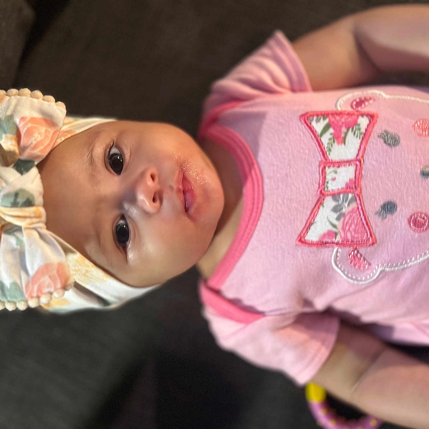 Rare joined the competition — help win amazing prizes! apparel, baby, baby_girl, bear_design, child, clothing, couch, cute, eyes, face, floral_pattern, headband, indoors, infant, person, pink_shirt, portrait, smiling, soft_lighting, young_child