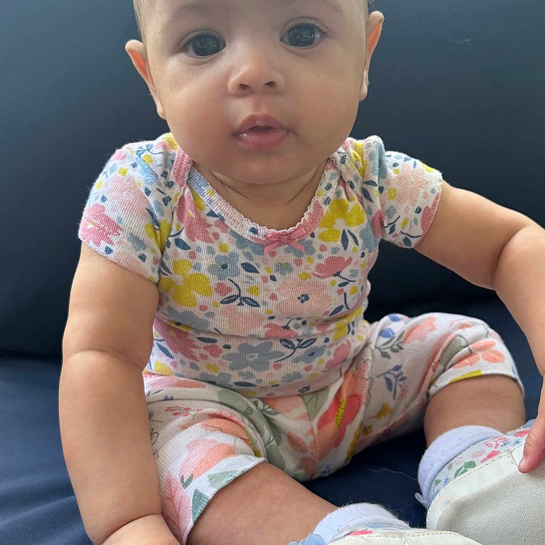 Rare joined the competition — help win amazing prizes! baby, child, comfortable, curious, cushion, cute, eyes, face, floral_clothing, footwear, hand, infant, natural_light, navy_blue, outdoor, portrait, sitting, skin, soft_shoes, young