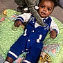 animal_print, baby, blue_outfit, carpet, child, colorful, cozy, cute, drool, indoor, infant, lying_down, plush_elephant, portrait, quilt, smiling, socks, soft_toy, toy, white_sleeves