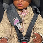 Maëlys a rejoint le concours — aidez-le/la à gagner de superbes lots ! baby, baby_gear, black_hair, car_seat, child, closeup, clothing, cute, expression, face, hand, indoors, infant, knitwear, pacifier, portrait, safety_harness, seat, seatbelt, young_child