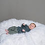 Soli joined the competition — help win amazing prizes! baby, infant, child, green_clothing, checkered_shirt, pants, white_fur, fluffy_surface, gray_background, portrait, indoor, relaxed, lying_down, small_hands, small_feet, cute, soft_texture, calm, young, person