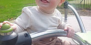 Alfie joined the competition — help win amazing prizes! toddler, child, playground, outdoor, metal_bar, smile, happy, cute, clothing, pants, shirt, blue_socks, sunlight, green_grass, nature, park, person, face, play, joy