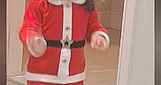 Shanaya is registered to the contest to win money with this photo: child, toddler, santa_costume, christmas, red_clothing, white_trim, standing, indoors, doorway, hallway, wooden_floor, portrait, long_hair, smiling, festive, holiday, costume, shoes, mirror, social_media_screenshot
