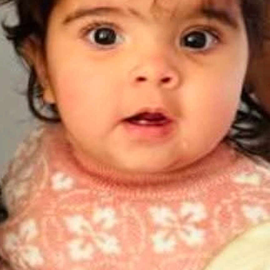 Shanaya joined the competition — help win amazing prizes! baby, infant, child, portrait, face, wide_eyes, looking_at_camera, brown_hair, hair_clip, pink_sweater, floral_pattern, clothing, indoor, close_up, seated, cozy, cute, social_media_screenshot, photography, headshot