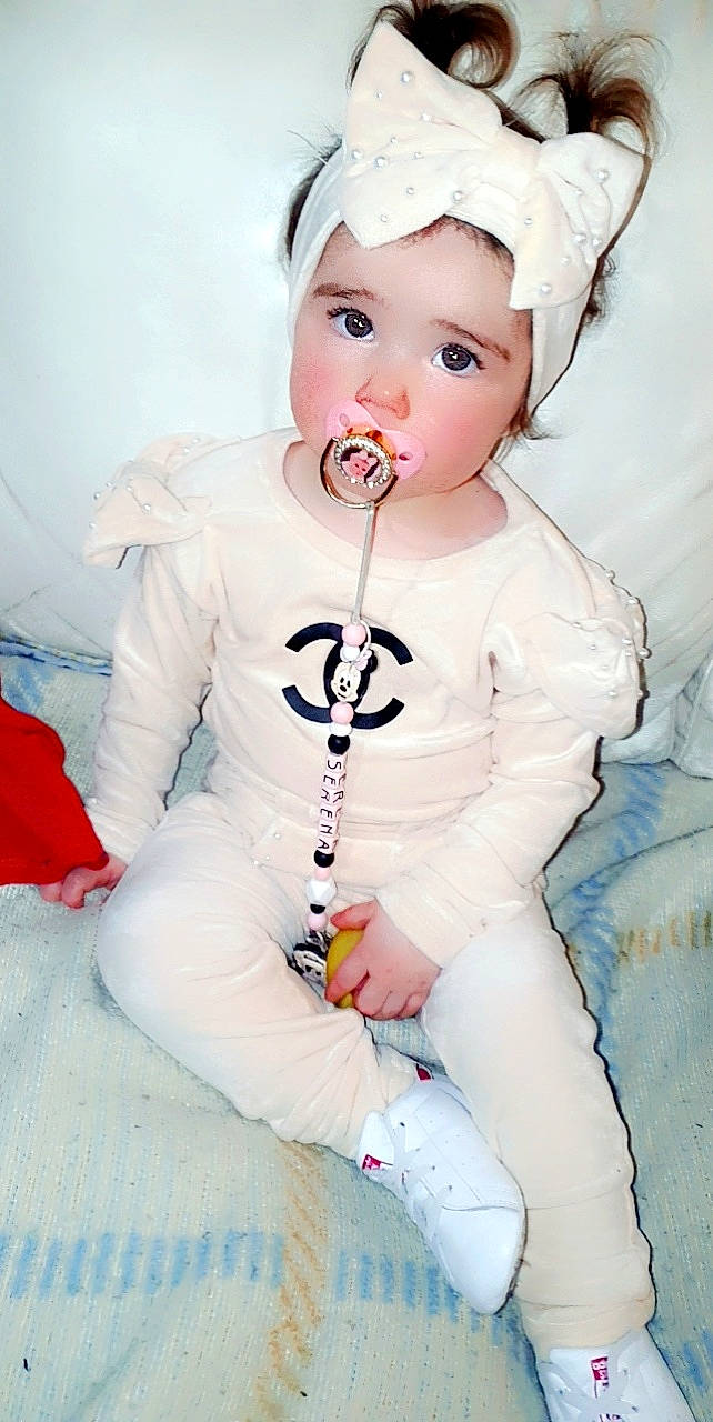 Séréna participe au concours pour gagner de l'argent avec cette photo : baby, baby_toddler_clothing, cap, carmine, cheek, child, eye, eyelash, fashion_accessory, fun, happy, headwear, lip, person, pink, portrait_photography, sitting, skin, sleeve, textile