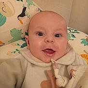 Léon participe au concours pour gagner de l'argent avec cette photo : baby, infant, smiling, pacifier, pillow, bedding, onesie, closeup, portrait, mouth_open, big_eyes, blanket, animal_print, cute, indoors, head, cheeks, skin, pattern, toy