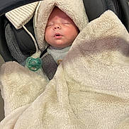 Maël participe au concours pour gagner de l'argent avec cette photo : baby, blanket, car_seat, child, sleeping, pacifier, hood, cozy, infant, soft_texture, toddler, indoor, cute, resting, wrapped, warm, face, person, seatbelt, carrying_handle