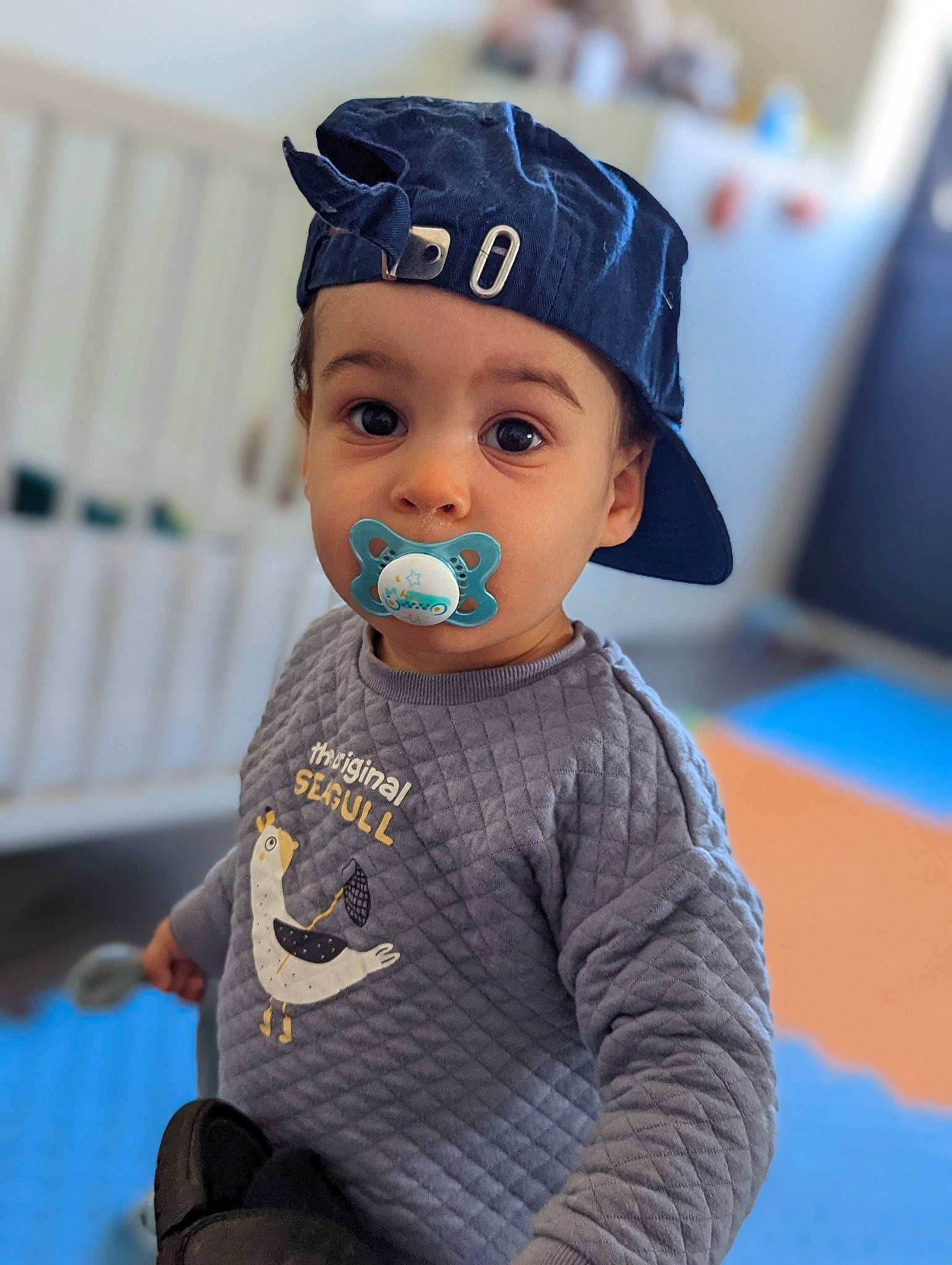 Eren a rejoint le concours — aidez-le/la à gagner de superbes lots ! baby_toddler_clothing, baseball_cap, cap, child, elbow, electric_blue, face, fashion_accessory, flooring, fun, gesture, happy, headwear, helmet, person, personal_protective_equipment, sitting, sleeve, sports, sports_gear