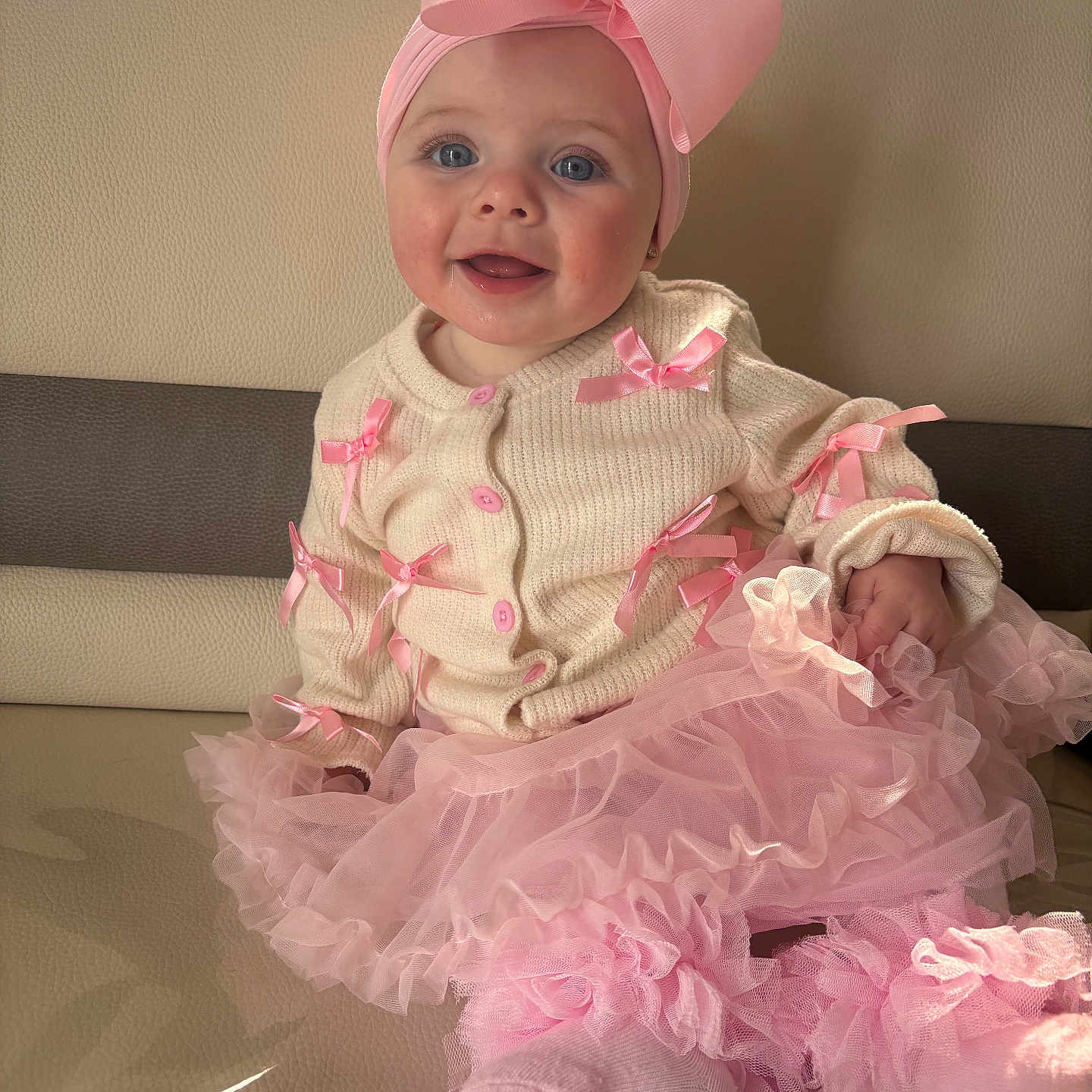 Anna participe au concours pour gagner de l'argent avec cette photo : baby, child, pink_bow, headband, sweater, pink_ribbons, tutu, frills, socks, smiling, blue_eyes, couch, indoor, portrait, cute, happy, infant, clothing, fashion, soft_light
