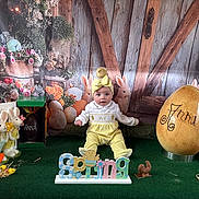 Anna a rejoint le concours — aidez-le/la à gagner de superbes lots ! baby, child, yellow_clothing, bow, chick, plush_bunny, easter_egg, spring_sign, decorations, green_carpet, wooden_backdrop, flowers, eggs, cute, holiday, portrait, indoor, celebration, smiling, festive