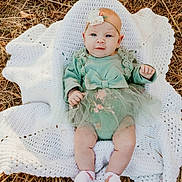 Lydia joined the competition — help win amazing prizes! baby, infant, child, green_outfit, bow, headband, flower, blanket, crochet, grass, outdoor, nature, cute, portrait, sitting, smile, legs, feet, white_socks, fall