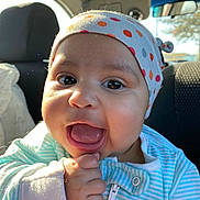 Nyla joined the competition — help win amazing prizes! baby, child, smiling, happy, face, headband, clothing, striped, car_interior, seat, hand, mouth_open, cute, infant, portrait, young_child, bright, daylight, closeup, expressive