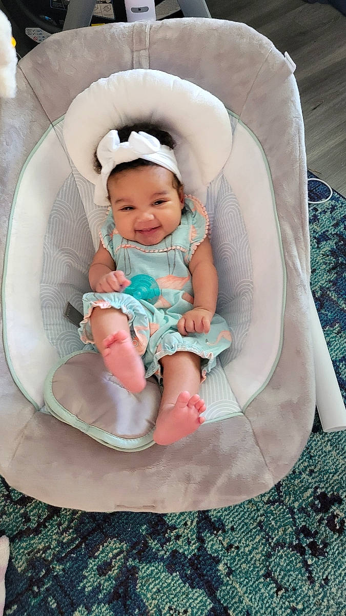 Mila is registered to the contest to win money with this photo: baby, baby_carriage, baby_products, baby_safety, baby_toddler_clothing, chair, child, circle, comfort, fashion_accessory, finger, fun, grass, joy, lap, linens, pattern, person, sitting, sleeve