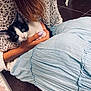 Aïko a rejoint le concours — aidez-le/la à gagner de superbes lots ! kitten, cat, person, hands, sitting, knitted_sweater, blue_skirt, floor_tiles, black_and_white_cat, nail_polish, cozy, indoor, pet, cute, animal, feline, resting, comfort, gentle, close_up