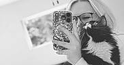 Willow joined the competition — help win amazing prizes! bed, black_and_white, blanket, cat, ceiling_fan, furniture, glasses, hand, home, indoor, long_hair, mirror, person, reflection, selfie, sleeve, smartphone, tuxedo_cat, whiskers, window