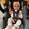 baby, infant, car_seat, child, floral_headband, floral_pants, pink_clothing, white_shoes, straps, safety_harness, cute, indoors, flooring, blanket, portrait, young_child, seated, expression, headwear, footwear