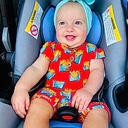 Oaklynn joined the competition — help win amazing prizes! baby, child, car_seat, headband, bow, red_outfit, french_fries_pattern, smile, happy, infant, sitting, blue_cushion, clothing, cute, portrait, seatbelt, indoor, person, skin, face
