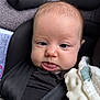 Laney is registered to the contest to win money with this photo: baby, infant, car_seat, face, tongue, straps, black_clothing, blanket, close_up, child, seatbelt, infant_seat, cute, expression, head, skin, person, safety, indoors, young_child