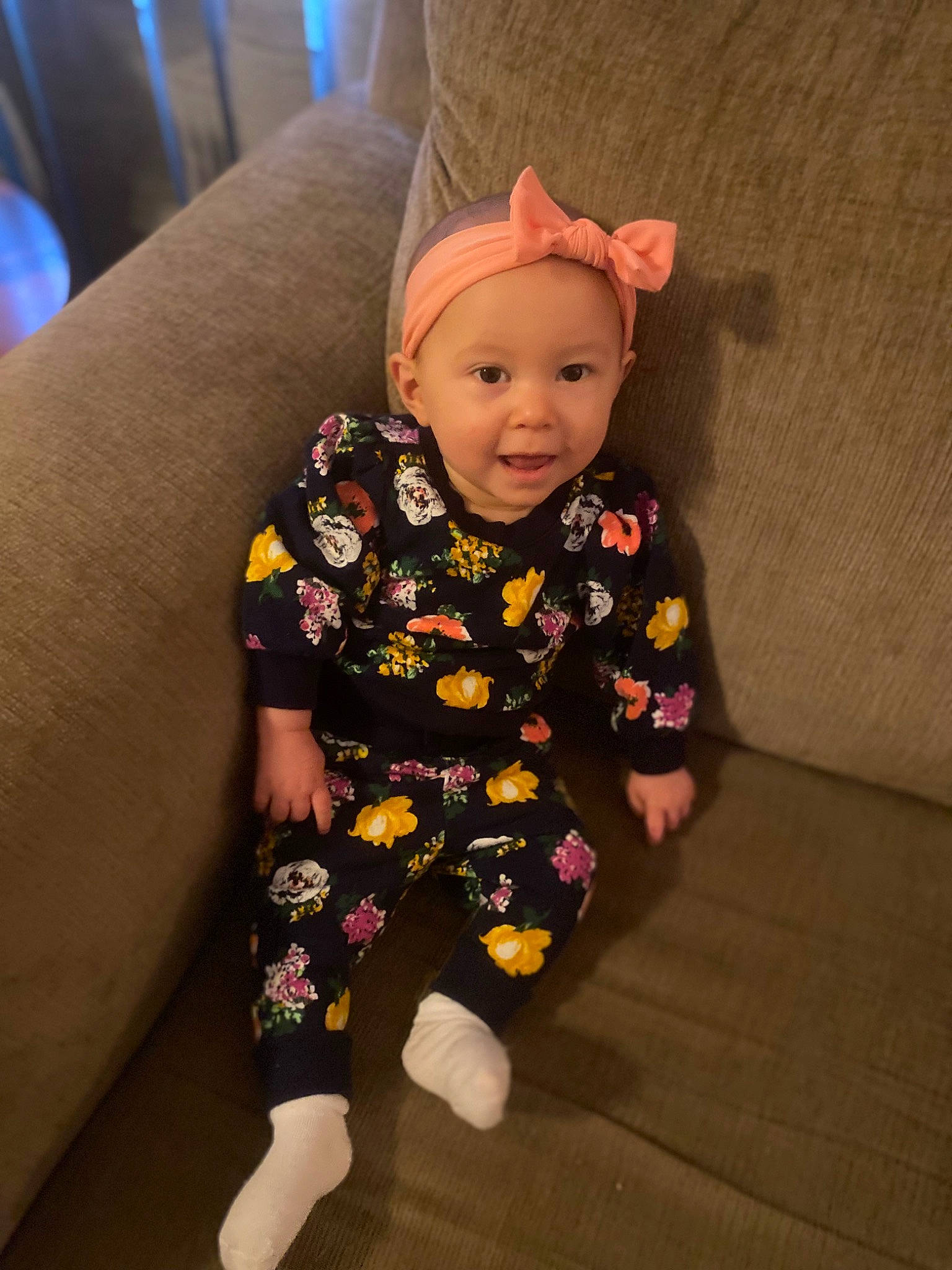 Emersyn is registered to the contest to win money with this photo: arm, baby, baby_laughing, baby_toddler_clothing, child, comfort, costume, couch, flooring, fun, happy, headwear, human_leg, magenta, pattern, person, sitting, sleeve, smile, sock